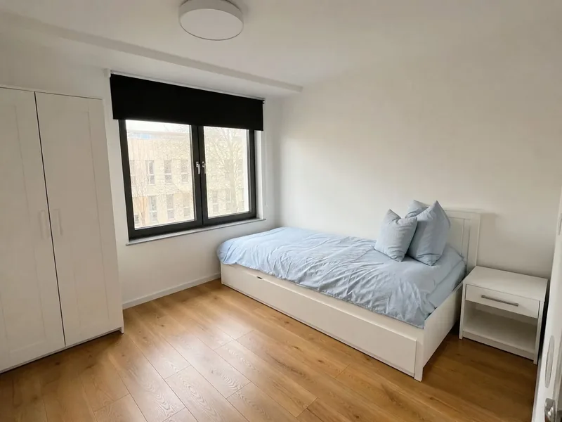 Einzelzimmer mit Bett, Schrank und Fenster
