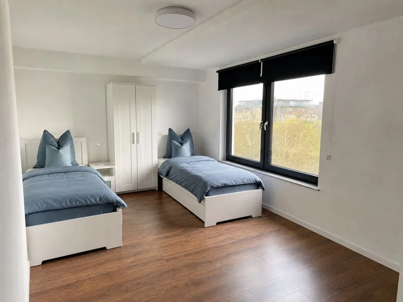 Zweibettzimmer mit zwei getrennten Einzelbetten und Kleiderschrank