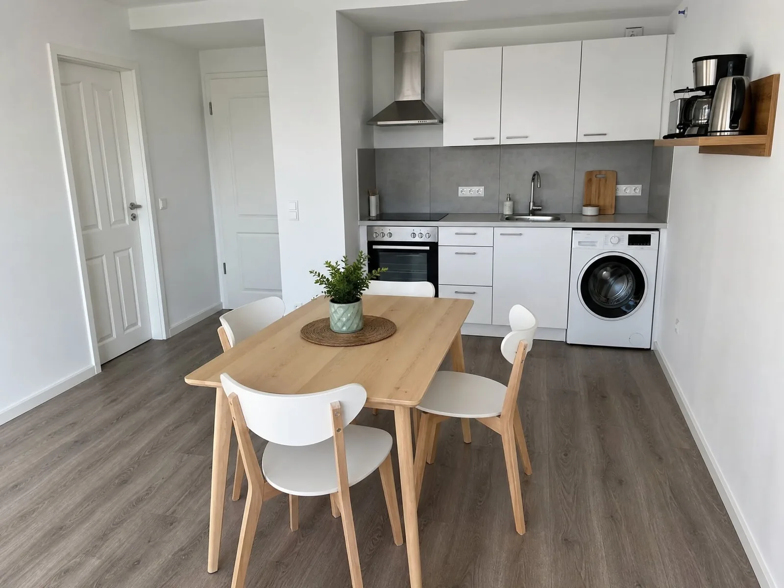 Küche mit Holztisch, Backofen und Waschmaschine